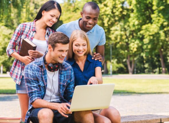 group of students discussing something looking at a laptop