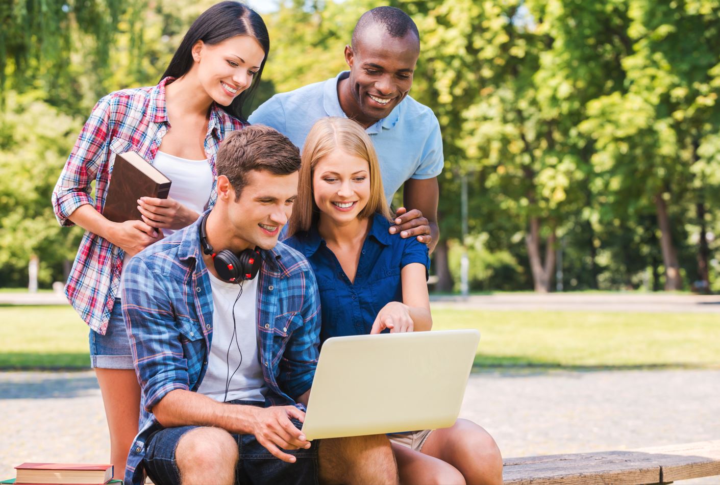 group of students discussing something looking at a laptop